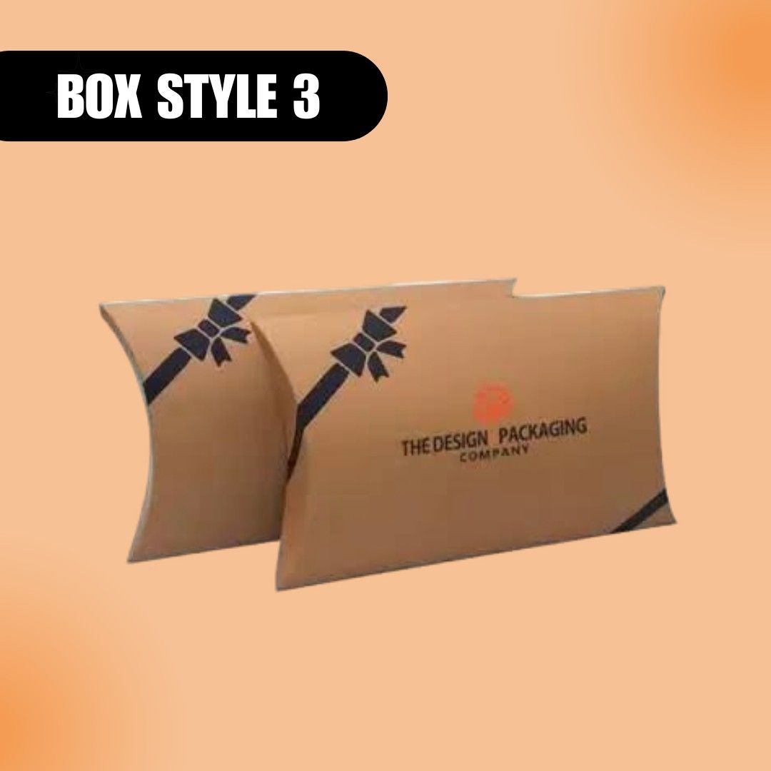 Tan pillow-style packaging boxes with black ribbon design and company logo are displayed on a peach background. Text reads "Box Style 3" in bold.