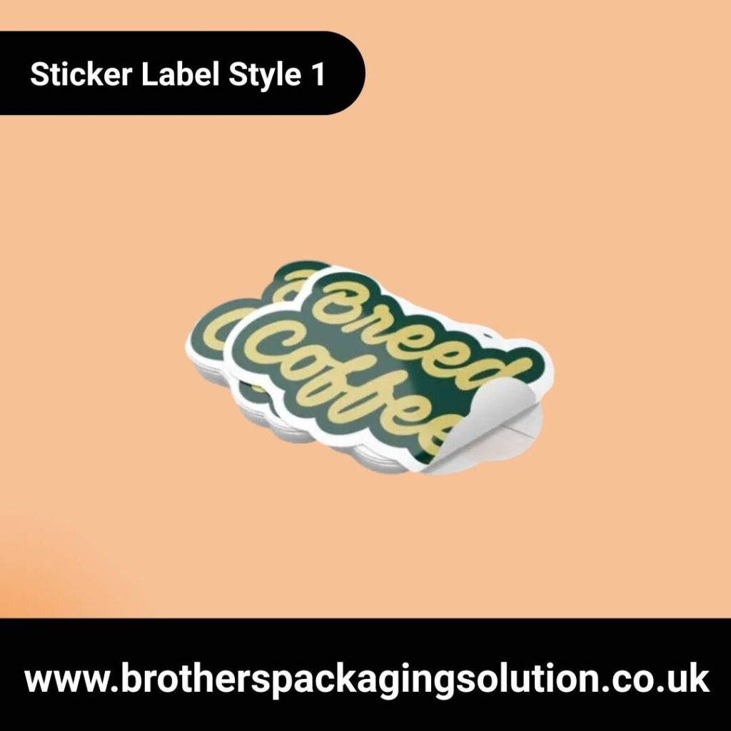 Stack of stickers with "Brewed Coffee" text in yellow on a green background. One sticker's edge is peeling. Soft peach background.
